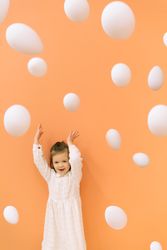 Happy girl throwing eggs in room
