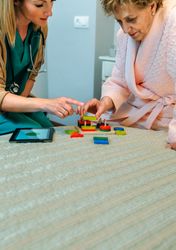 Female doctor showing geometric shapes to mature patient