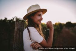 Portrait of a young woman leaning on a post outdoors e4BPE0