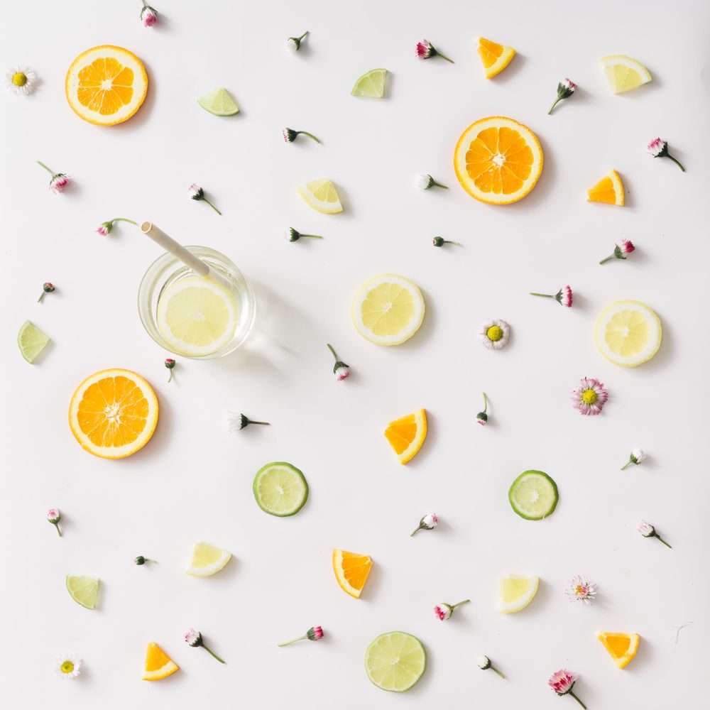 Colorful pattern made of orange, lemon, lime and flowers with lemonade
