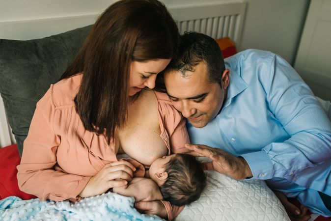 Mom near father breastfeeding at home