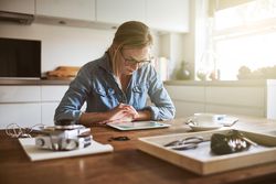 Woman working on tablet in her kitchen