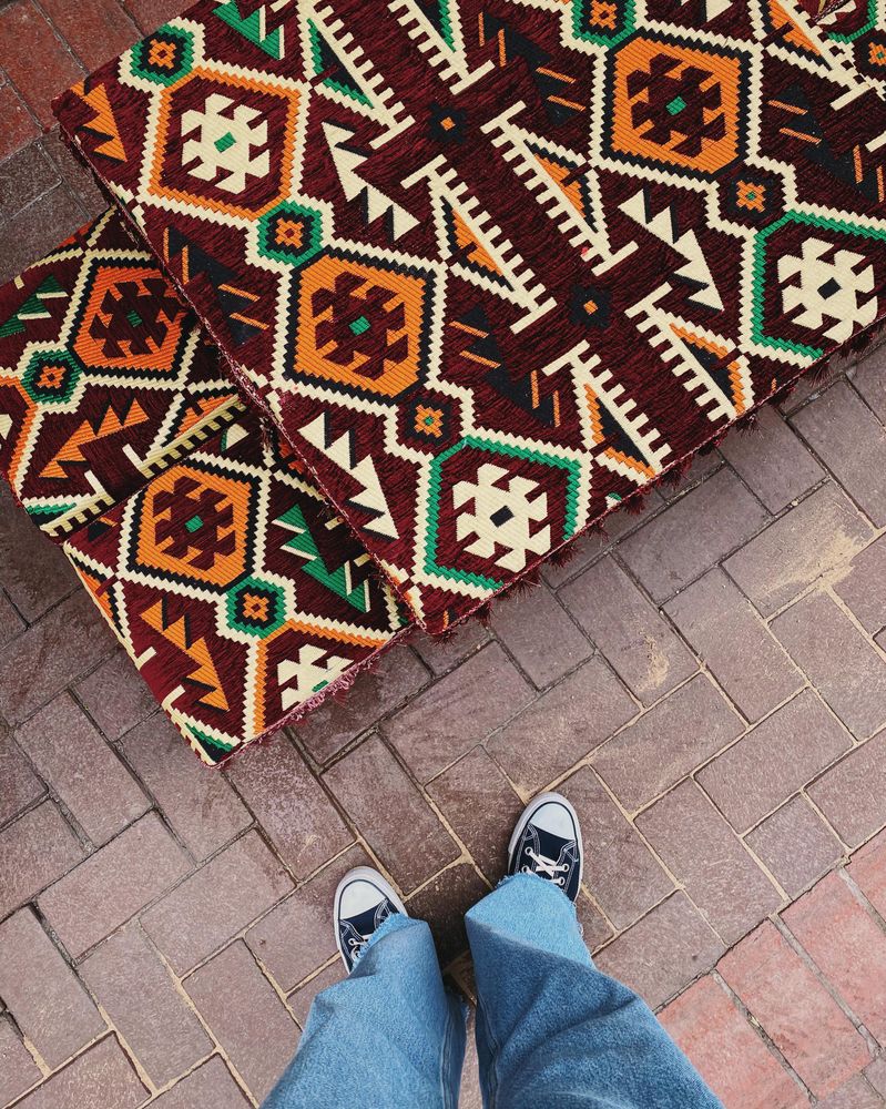 Looking down at feet next to a patterned table