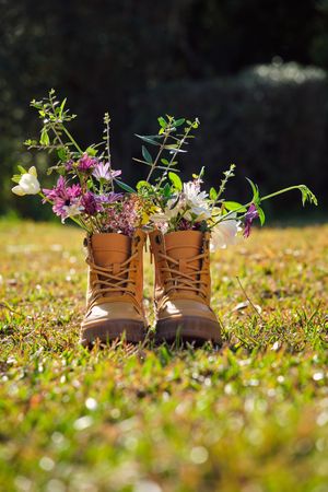 Pair of boots with flowers on grassy ground