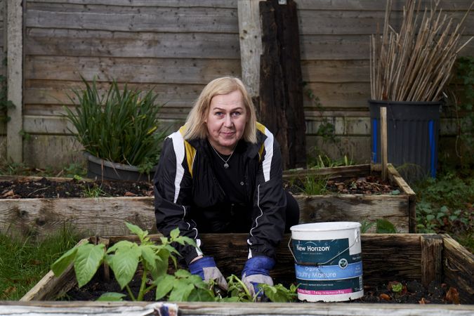 Woman gardening in a raised bed wearing gloves