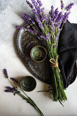 Delicate summer table setting with lavender flowers on dark plate