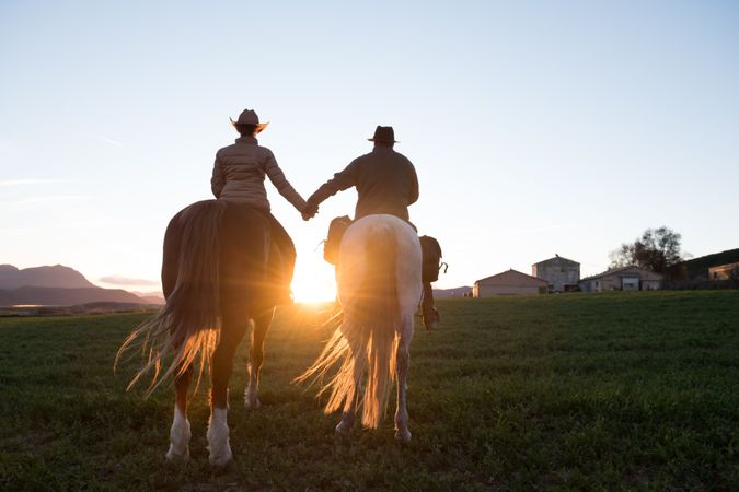 People on horses holding hands
