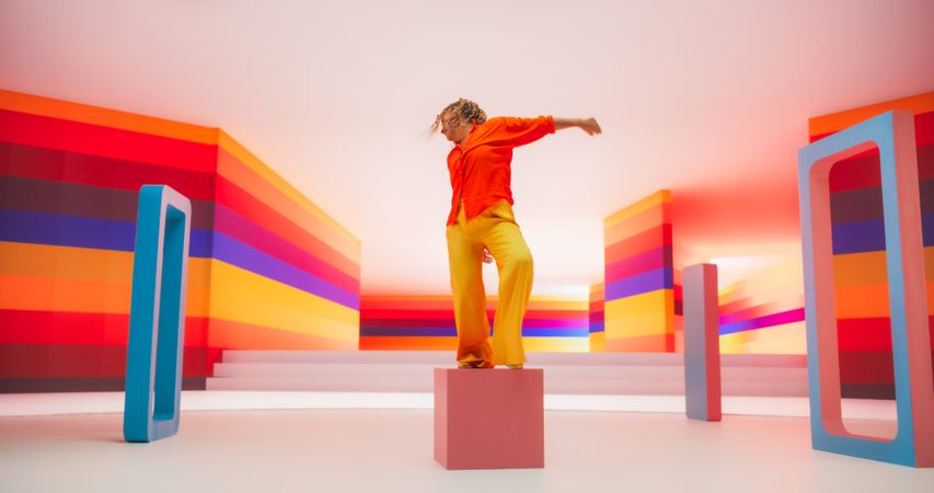 Portrait of a Talented Black Female Artist Showcasing Dance Movements in Abstract Colorful Studio Decoration.
