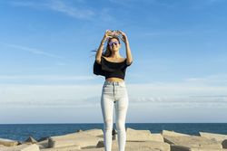 Young female traveler in sunglasses taking selfie in Barcelona city at the coast