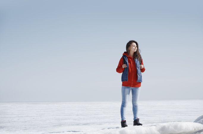 Young adult woman outdoors travelling in icy landscape with back