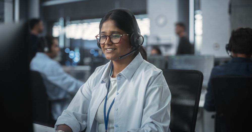 Indian Female Using a Headset to Have a Conversation with a Tech Team
