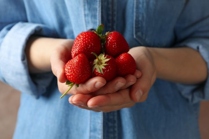 Woman holds bowl with tasty strawberry, close up. Summer berry