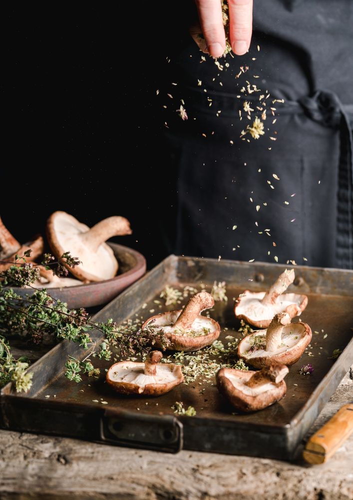 Cook preparing fresh brown mushrooms for baking