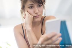 Confused woman reading something on phone 5qwpab