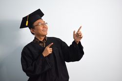 Excited male graduate in studio shoot