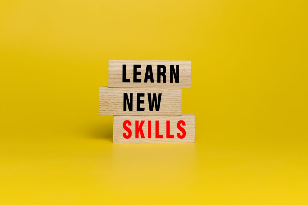 learn new skills words text on wooden blocks isolated on yellow background