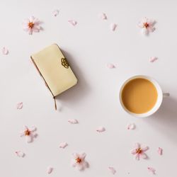 Vintage book on light background with pink flowers and cup of coffee or tea