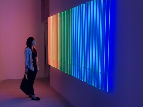 Woman looking at a colorful neon light