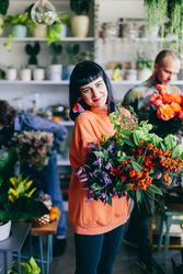 Woman carrying flowers in the flower shop.