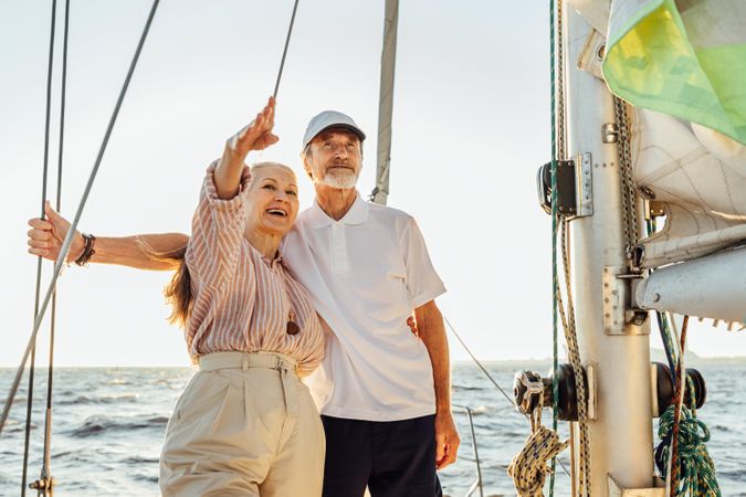 Happy older couple on a boat looking at something in the distance