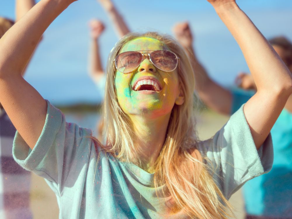 Woman Blonde Girl Dances in Celebration of Holi Festival With Her Friends.