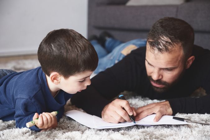 Father and son drawing on floor