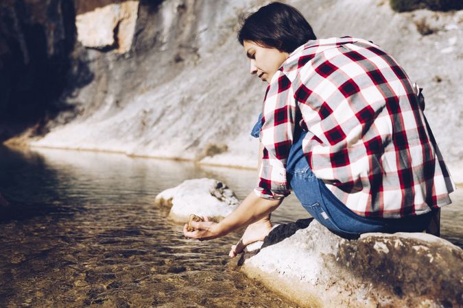 Woman on rock in beautiful lake