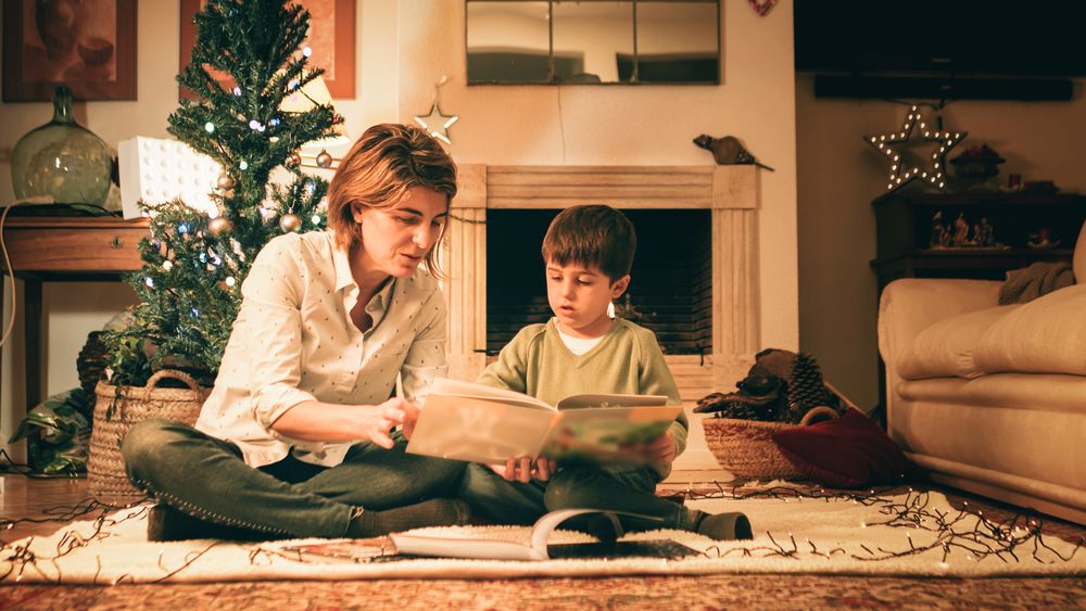 Mother reading book with son on Christmas eve
