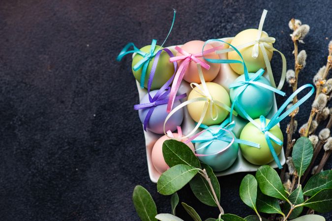 Easter holiday card concept with carton of pastel decorative eggs