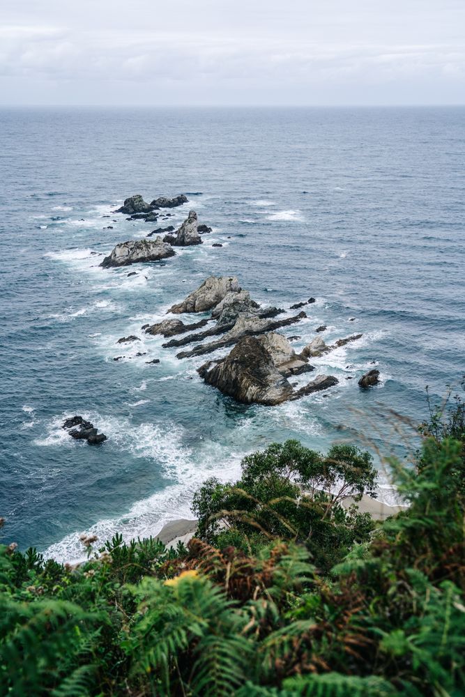 Rocky peaks surrounded by foamy water in windy day