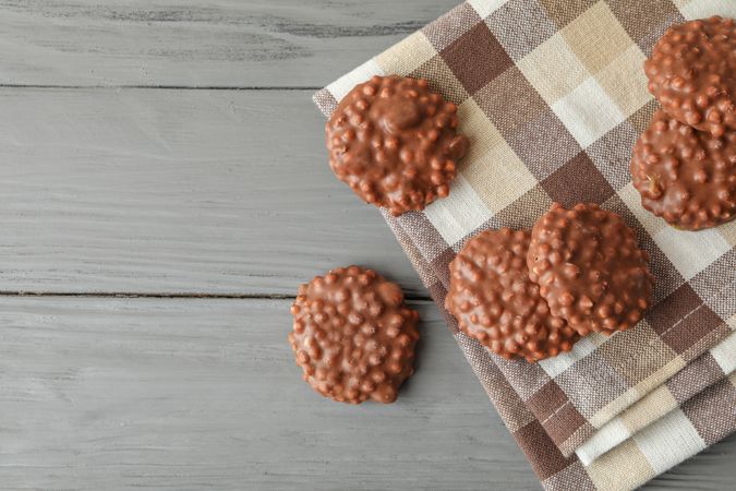 Kitchen towel with chocolate cookies on grey table, space for text