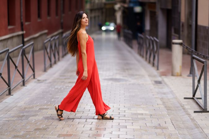 A stylish woman enjoys a leisurely stroll in a bustling urban setting, exuding confidence
