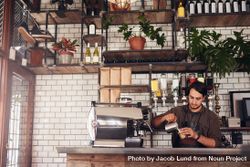 Indoor shot of young male barista making a cup of coffee 5pPEw5