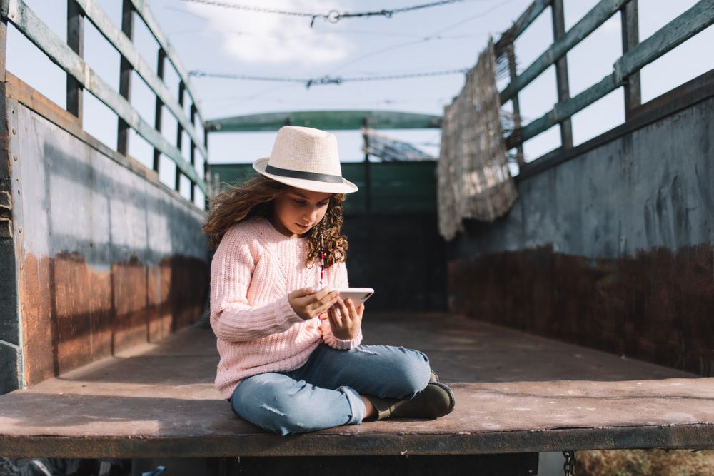 Focused girl using smartphone in countryside
