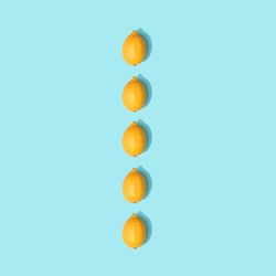 Row of lemons on pastel blue background