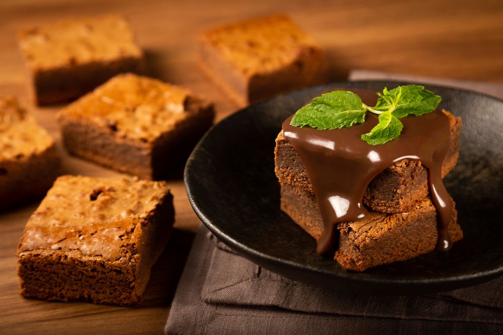 Freshly made chocolate brownies with chocolate syrup and fresh mint leaves
