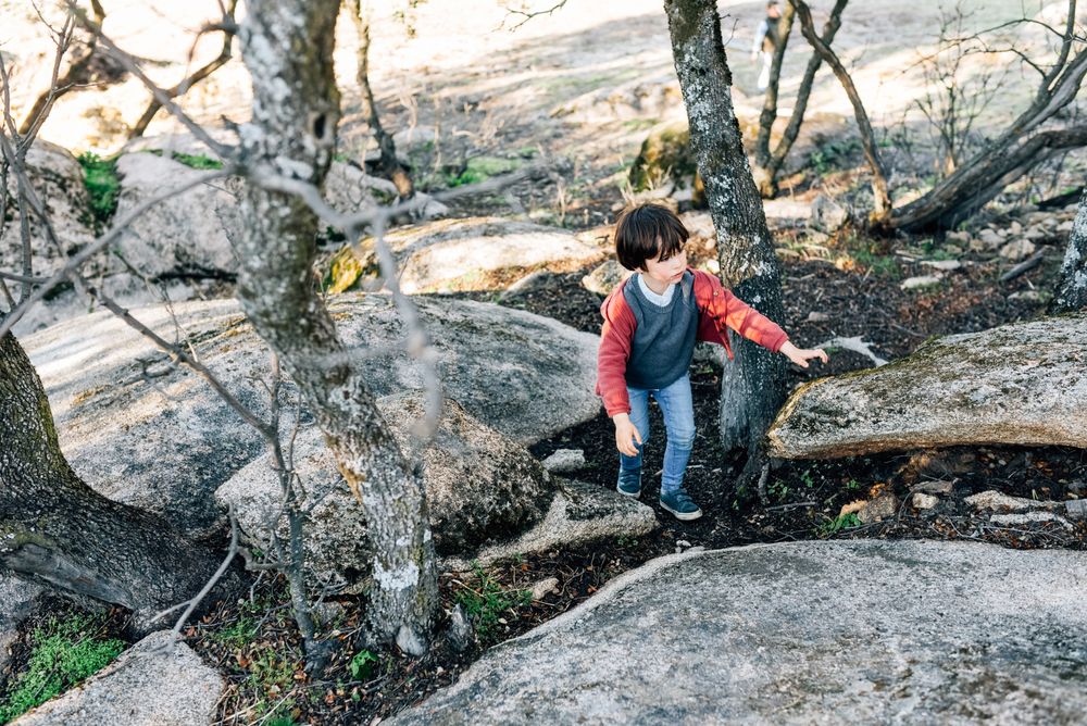 Little boy walking on rocky hill