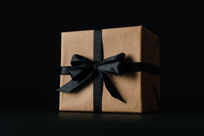 Gift box with dark bow on dark background