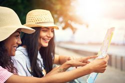 Beautiful women looking at a city map on a sunny day