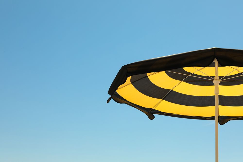 Striped beach umbrella against blue sky