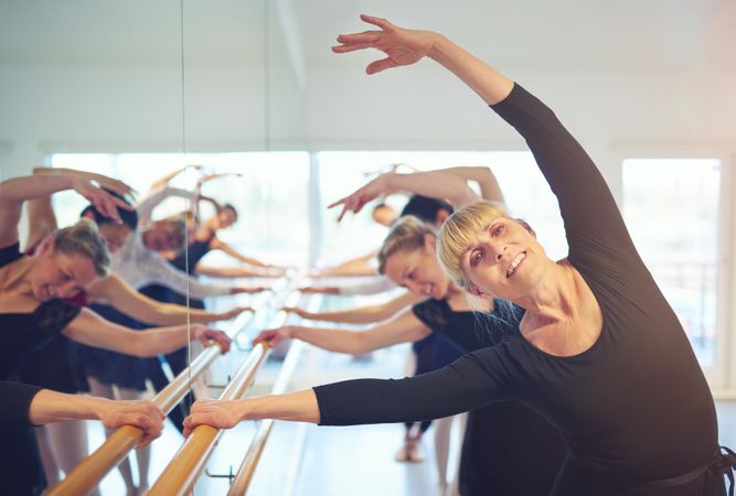Group of women stretching at barre in dance studio