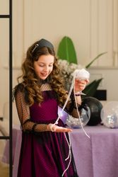 Girl examining pearls and smiling at birthday party