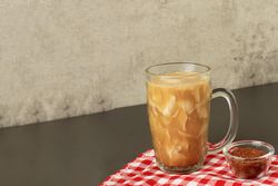Side view of Indonesian coconut drink on red tablecloth with copy space