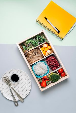 Food box with diet ingredients by copybook and plate