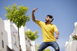 Excited guy taking selfie on street