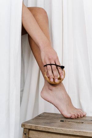 Cropped image of a woman holding dry brush scrubbing her leg
