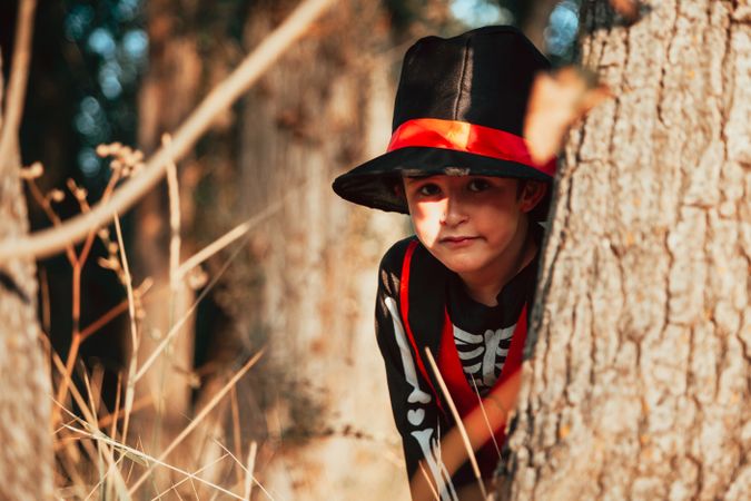 Boy in skeleton costume playing in the forest