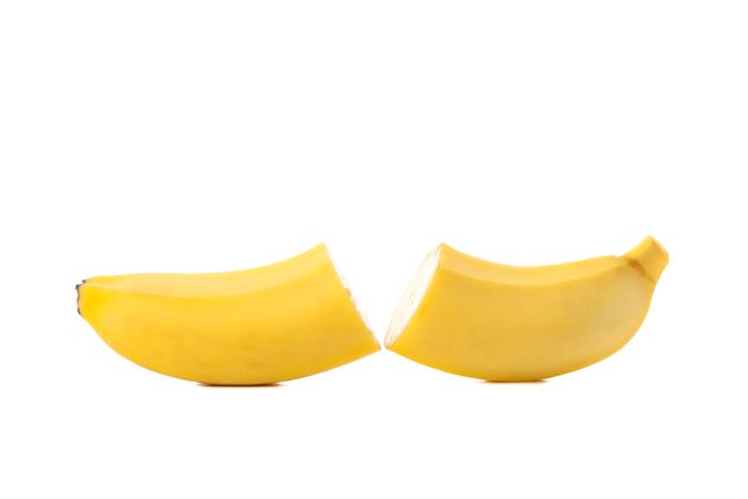 Banana halves isolated on neutral background. Fresh fruit