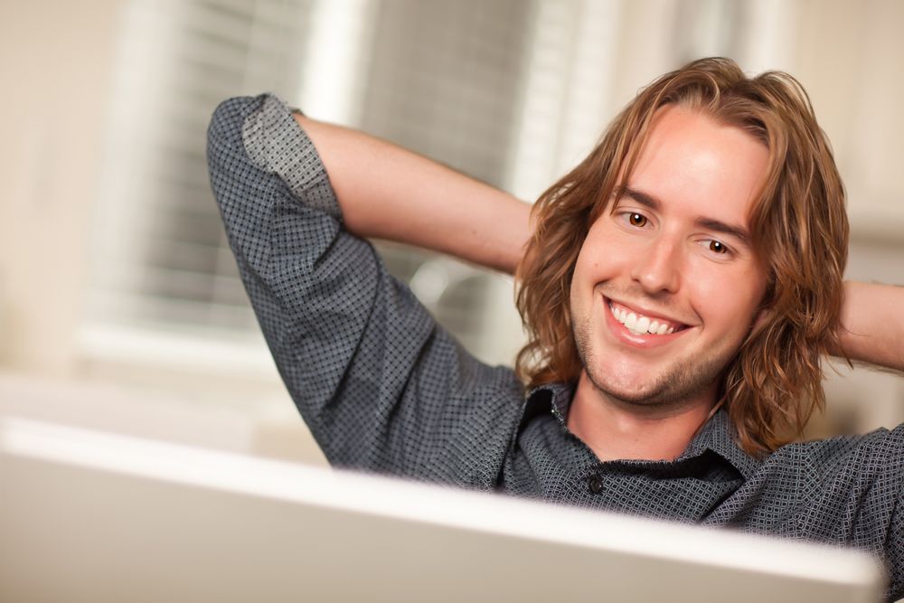Happy Young Man Using Laptop Computer