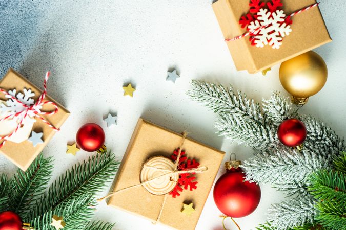 Top view of counter with fir branch, red & gold baubles and three presents